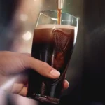 Pint of Guinness being poured into a branded glass